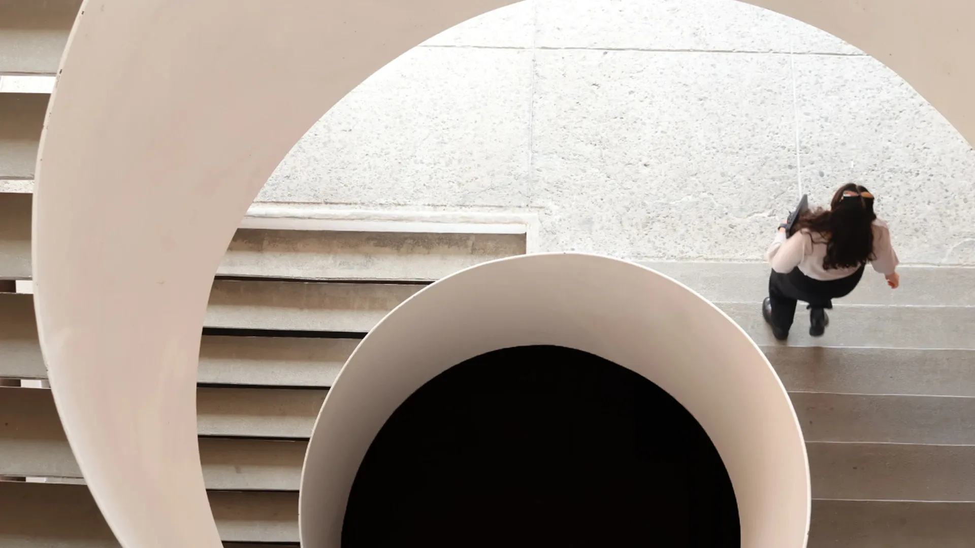 Estudiante bajando las escaleras del edificio Q en la IBERO.
