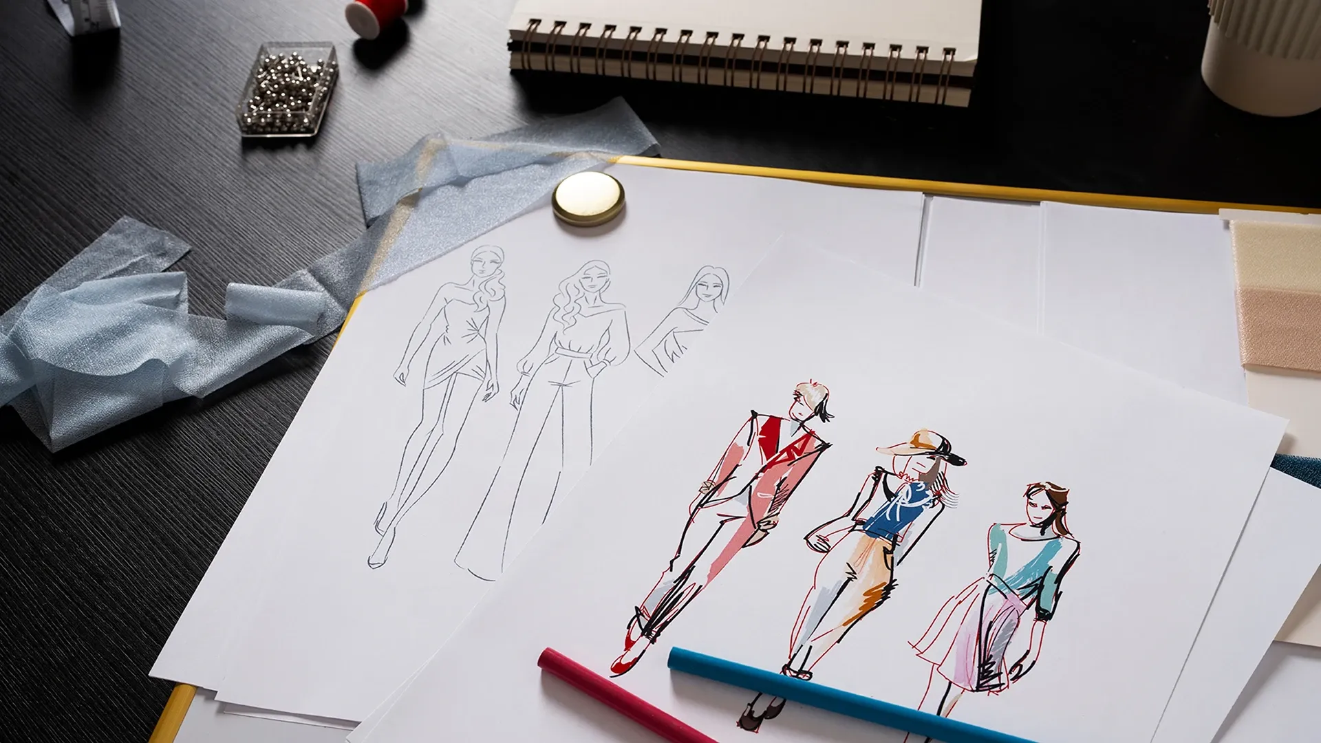  Bocetos con diseños de vestidos sobre un escritorio.
