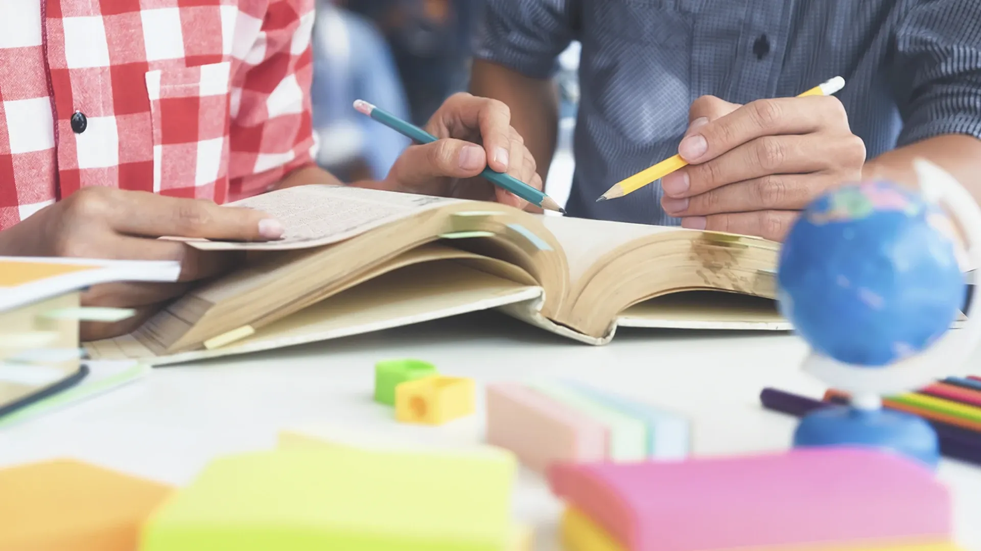  Personas trabajando frente a un libro.