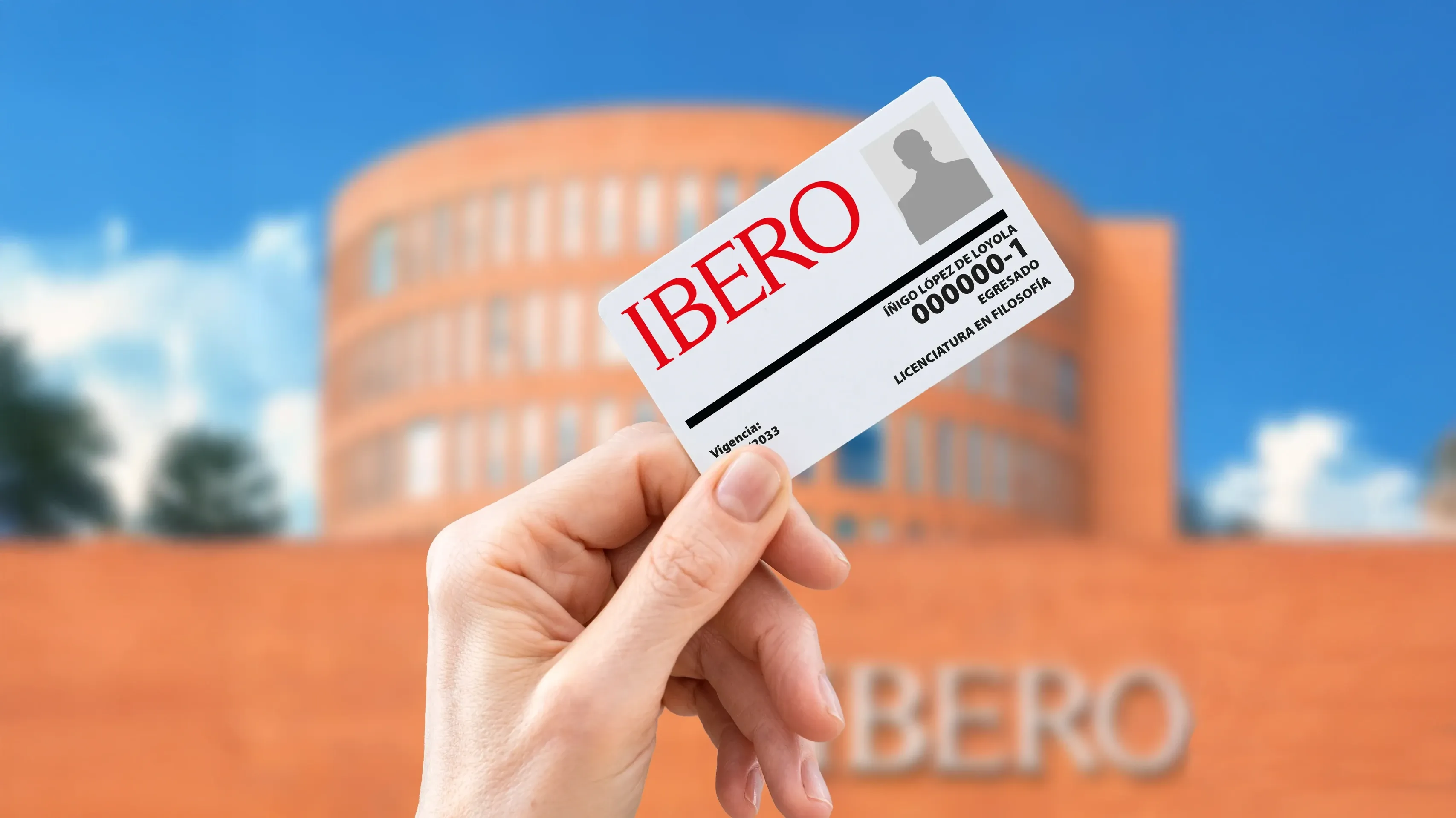 Persona egresada IBERO con una sudadera rojo, el logo de la universidad bordado y una sonrisa calida.